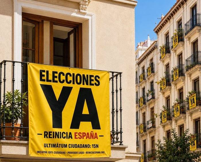 Bandera Elecciones ya colgada en un balcón y, al fondo, una calle con banderas iguales en cada ventana